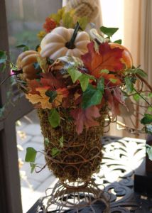 moss filled wire urns overflow with gourds, leaves and ivy.